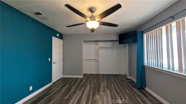 unfurnished bedroom with a closet, visible vents, baseboards, and wood finished floors