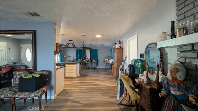 interior space featuring light wood-style flooring, visible vents, open floor plan, and a textured ceiling