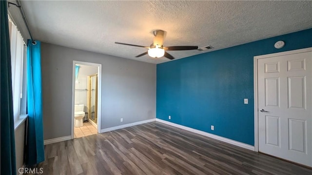 unfurnished bedroom featuring visible vents, a textured ceiling, wood finished floors, baseboards, and ceiling fan