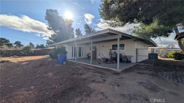 back of property featuring a gate, stucco siding, a patio, and fence