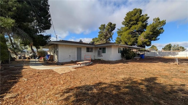 back of property with fence and stucco siding