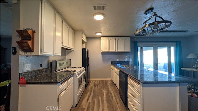 kitchen with visible vents, black appliances, a peninsula, and white cabinetry