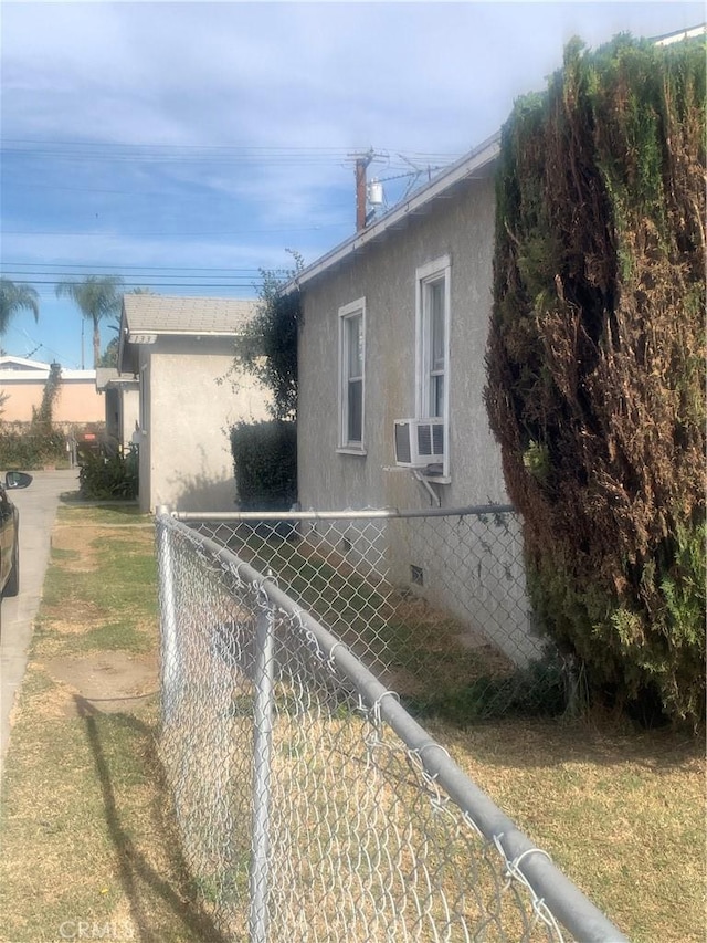 view of side of home with crawl space, stucco siding, cooling unit, and fence