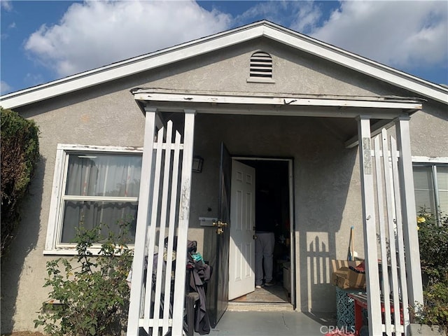 entrance to property featuring stucco siding