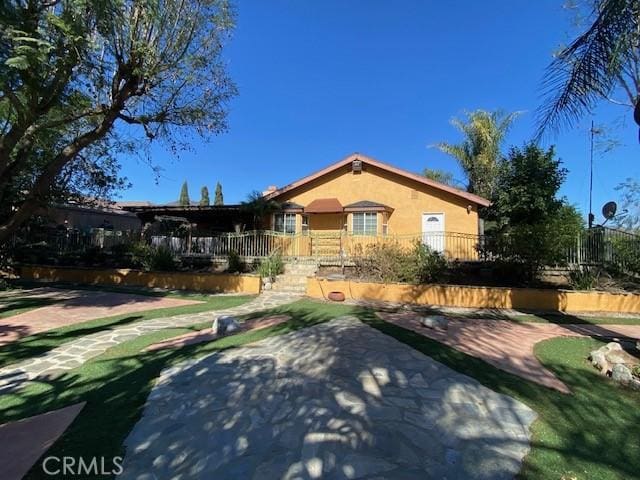 view of front of property featuring stucco siding and fence