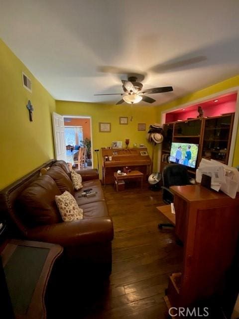 living area with visible vents, a ceiling fan, and wood-type flooring