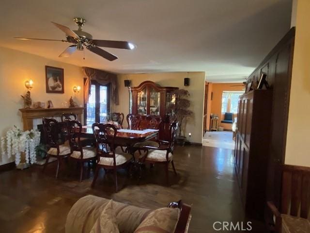 dining area featuring a fireplace, a healthy amount of sunlight, and ceiling fan