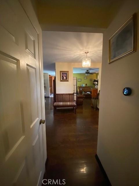 hall featuring an inviting chandelier and dark wood-style floors