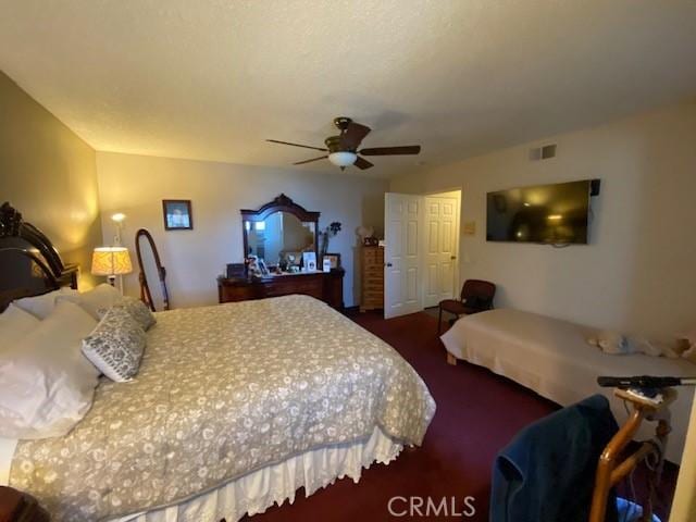 carpeted bedroom with a ceiling fan and visible vents