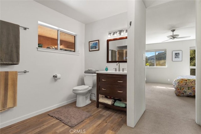 bathroom with vanity, wood finished floors, a ceiling fan, baseboards, and toilet