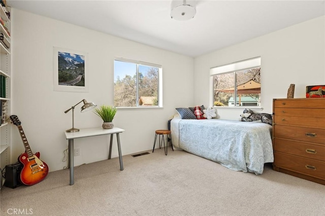 bedroom featuring visible vents, multiple windows, and carpet floors