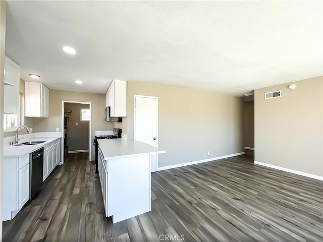 kitchen featuring visible vents, light countertops, gas range oven, dishwashing machine, and a sink