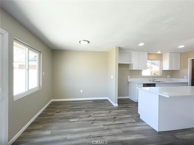 kitchen featuring plenty of natural light, white cabinets, light countertops, and baseboards