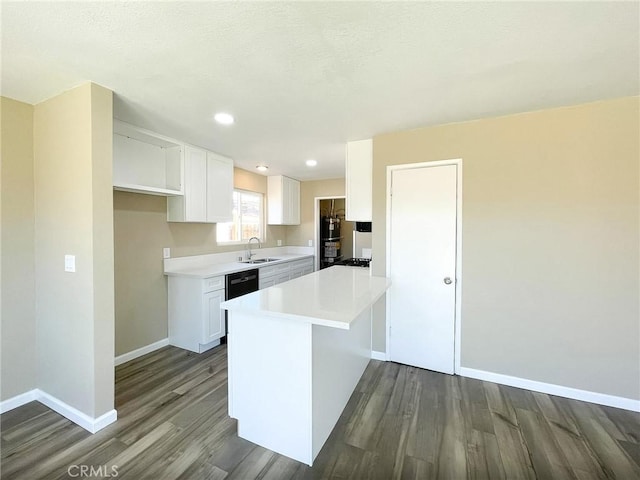 kitchen with white cabinets, dark wood-style floors, baseboards, and a sink