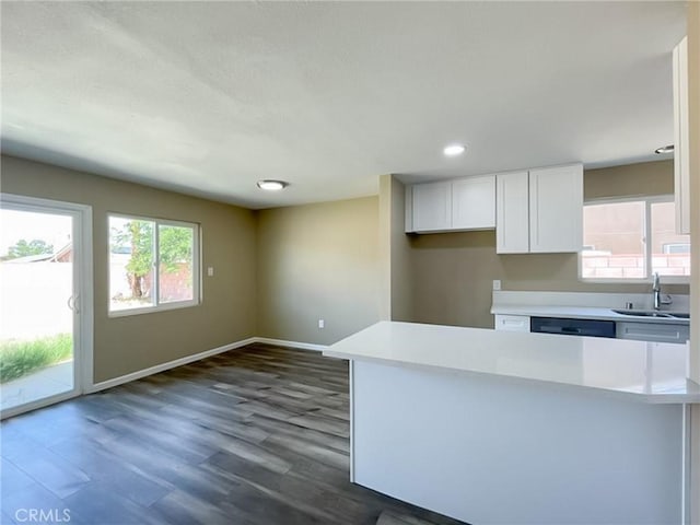45541 Sancroft Ave, Lancaster, CA 93535 - kitchen with a sink, white cabinets, light countertops, baseboards, and dark wood-style flooring