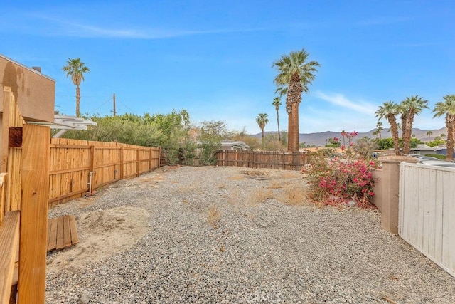 view of yard featuring a fenced backyard and a mountain view