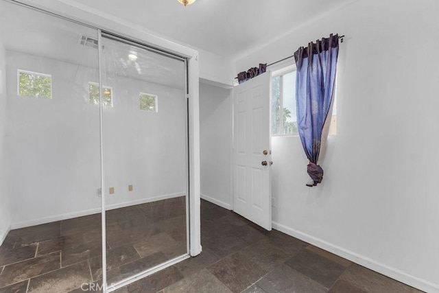 entrance foyer featuring visible vents, stone finish floor, and baseboards