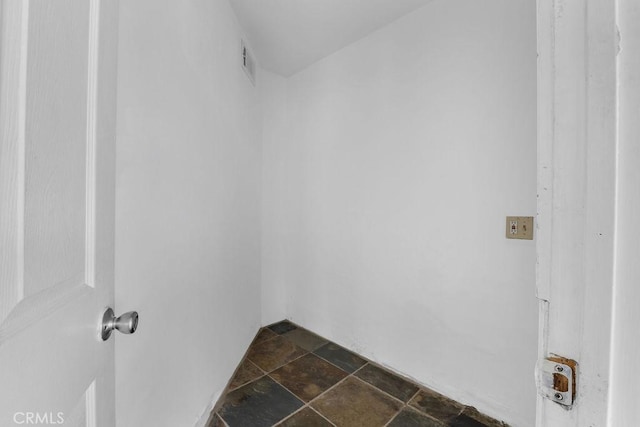 washroom with stone tile flooring and visible vents