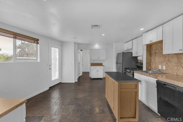 kitchen featuring stone tile floors, visible vents, stainless steel gas range, decorative backsplash, and dishwasher