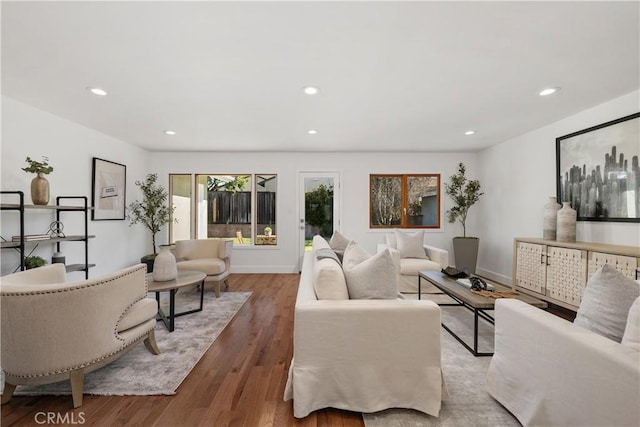 living room with recessed lighting, baseboards, and wood finished floors