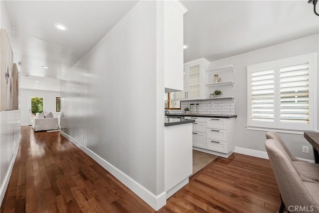 hallway featuring dark wood-style floors, recessed lighting, and baseboards