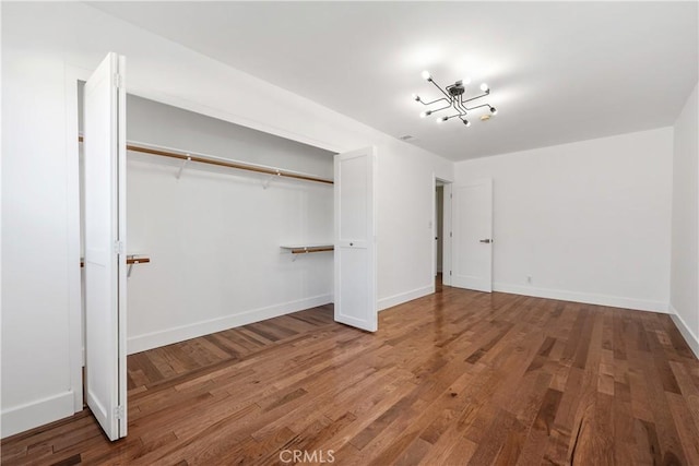 unfurnished bedroom featuring a closet, baseboards, and wood finished floors