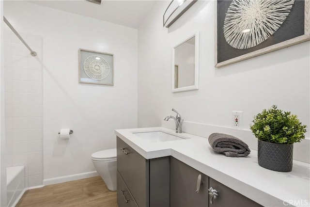 full bath featuring toilet, vanity, baseboards, and wood finished floors