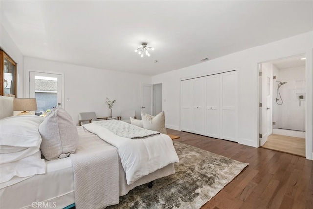 bedroom with visible vents, wood finished floors, a closet, and connected bathroom