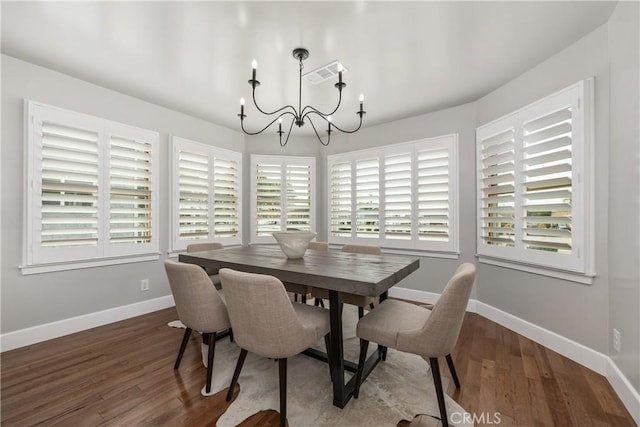 dining room with visible vents, wood finished floors, baseboards, and a chandelier