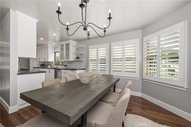 dining area featuring dark wood finished floors, recessed lighting, baseboards, and an inviting chandelier