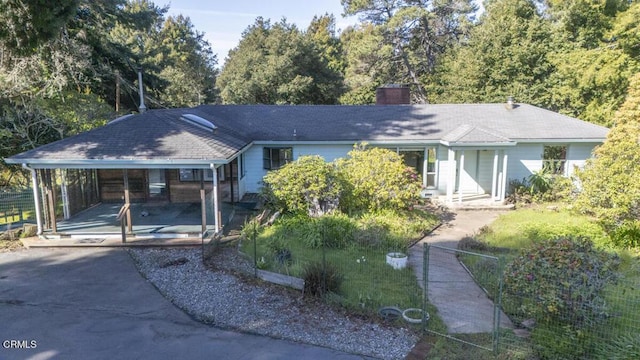 single story home with an attached carport, concrete driveway, and a chimney