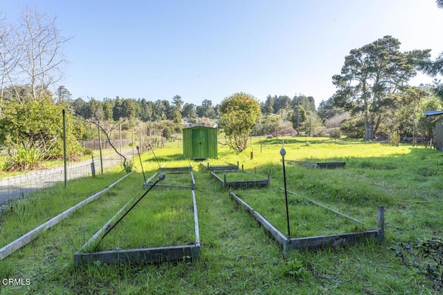 exterior space with a vegetable garden, a storage shed, and an outdoor structure