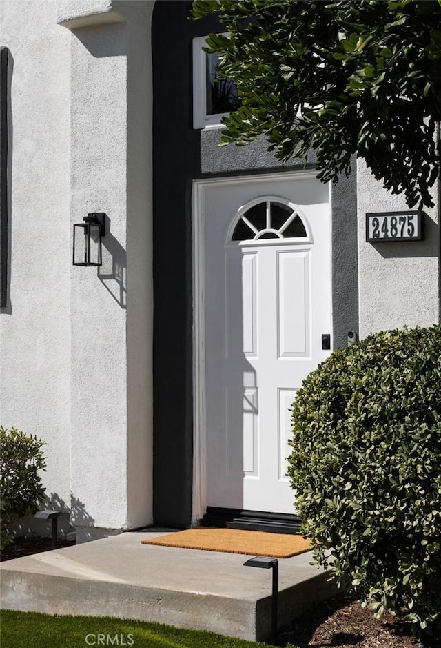 entrance to property featuring stucco siding