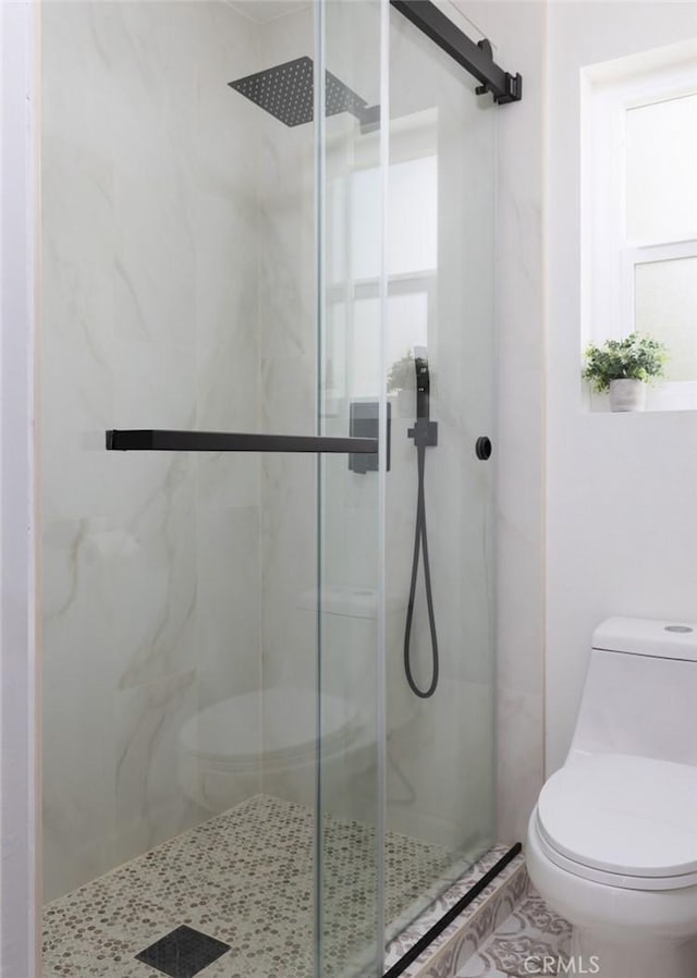 full bath with a marble finish shower, tile patterned floors, and toilet