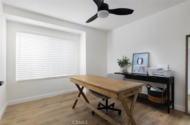 home office with light wood-style flooring, baseboards, and ceiling fan