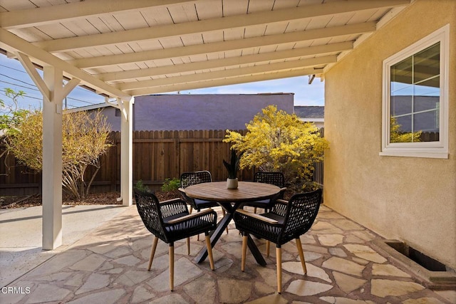 view of patio with outdoor dining space and fence