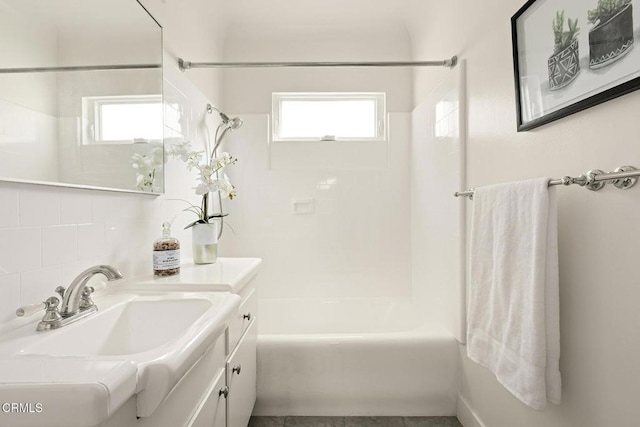 bathroom with backsplash, a healthy amount of sunlight, vanity, and  shower combination