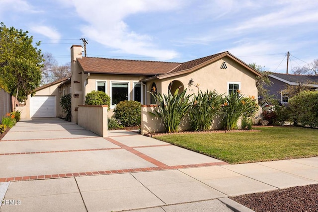 view of front facade with stucco siding, a chimney, concrete driveway, and a front yard