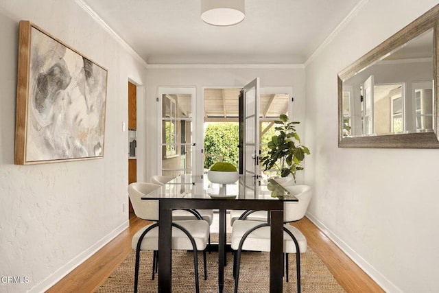 dining area with ornamental molding, baseboards, and wood finished floors