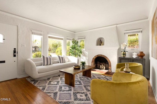 living room featuring a fireplace with flush hearth, wood finished floors, baseboards, and ornamental molding