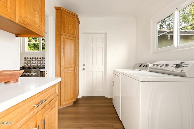 washroom with dark wood finished floors and washing machine and dryer