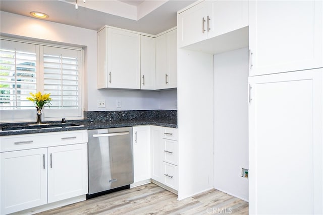 kitchen with a sink, white cabinets, light wood-style flooring, and stainless steel dishwasher