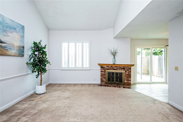 unfurnished living room with carpet flooring, a fireplace, a textured ceiling, and baseboards