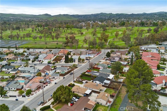 aerial view with golf course view, a residential view, and a mountain view