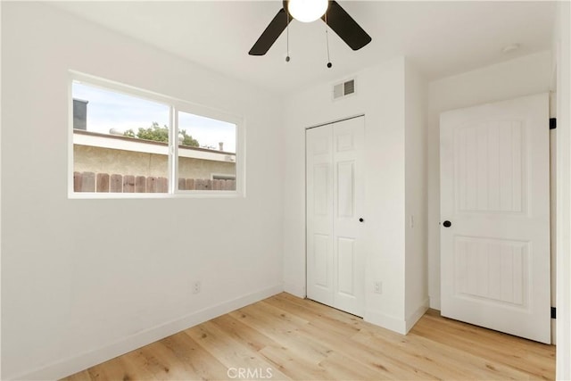 unfurnished bedroom featuring a closet, visible vents, light wood-type flooring, and baseboards