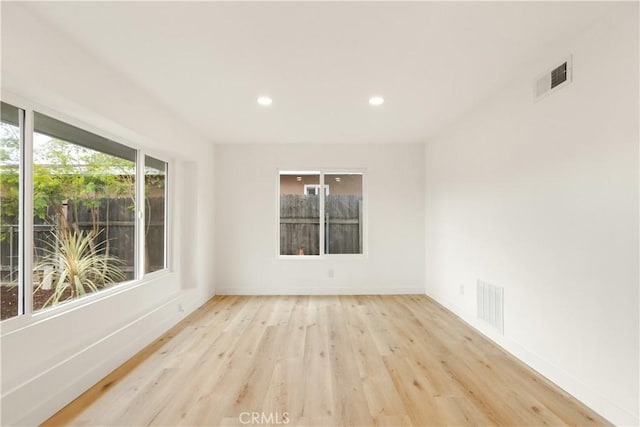 spare room with light wood-type flooring, visible vents, baseboards, and recessed lighting