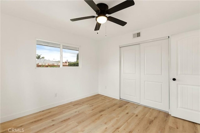 unfurnished bedroom featuring visible vents, light wood-style flooring, a closet, baseboards, and ceiling fan