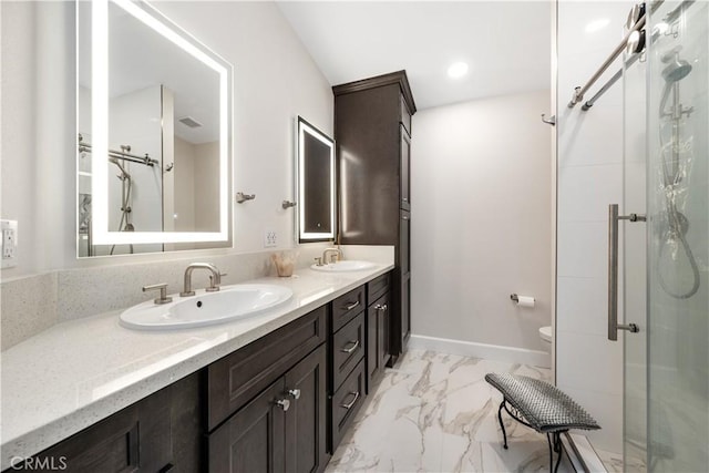 full bath with double vanity, marble finish floor, a stall shower, and a sink