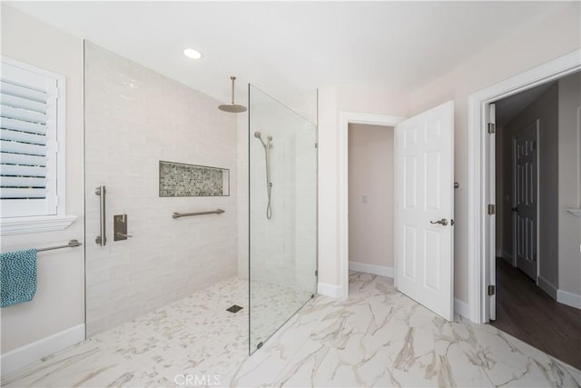 full bath featuring baseboards, marble finish floor, and walk in shower