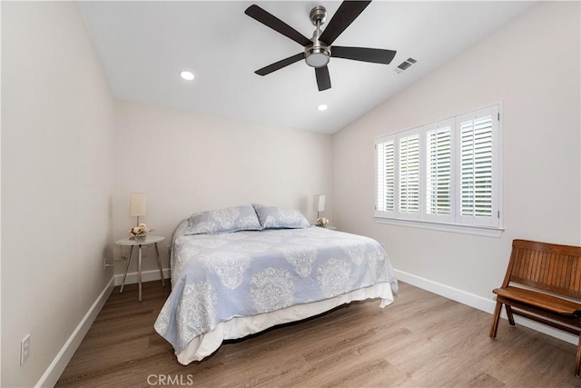 bedroom featuring visible vents, wood finished floors, recessed lighting, baseboards, and lofted ceiling